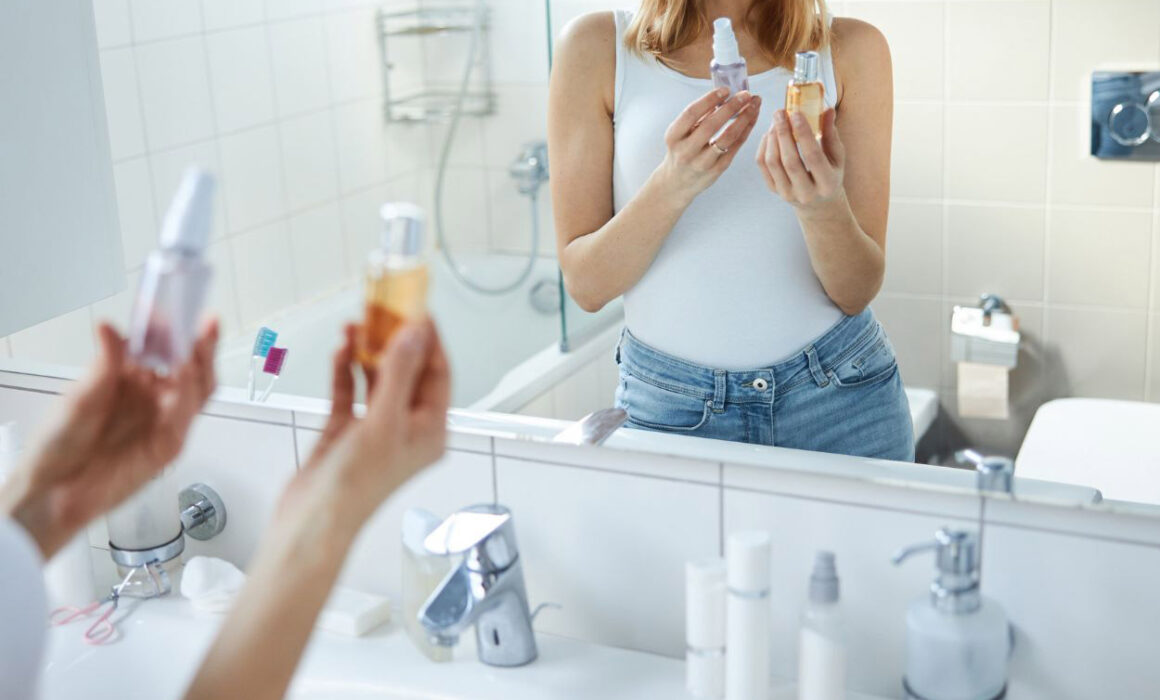 A woman in bathroom with beauty products in her hand